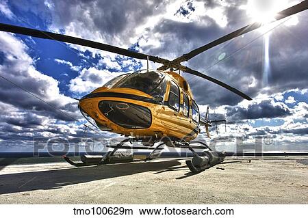 A Bell 407 utility helicopter on the helipad of an oil rig. View Large Photo Image Picture - A Bell 407 utility helicopter on the helipad of an oil rig.. Fotosearch