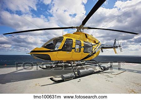 A Bell 407 utility helicopter on the helipad of an oil rig. View Large Photo Image Picture - A Bell 407 utility helicopter on the helipad of an oil rig.. Fotosearch
