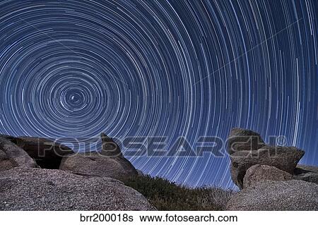Stock Photograph - A boulder outcropping and star trails in Anza Borrego Desert State Park, California.. Fotosearch