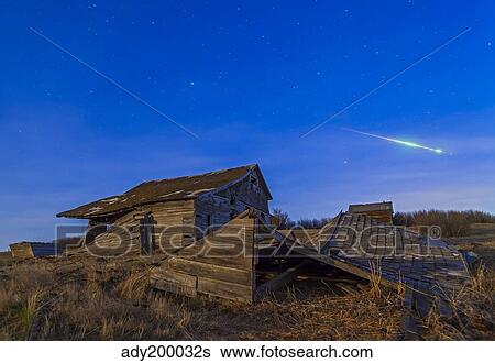 Stock Photograph - A bright bolide meteor breaking up as it enters the atmosphere.. Fotosearch