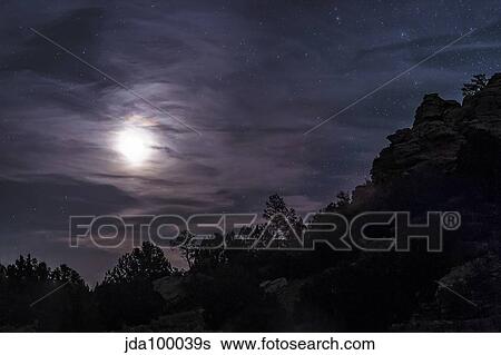 A bright moon rises through clouds over a hill in Oklahoma. View Large Photo Image Stock Photograph - A bright moon rises through clouds over a hill in Oklahoma.. Fotosearch