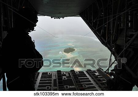 A bundle of donated goods drifts to an island after being dropped out the back of a C-130 Hercules. View Large Photo Image Picture - A bundle of donated goods drifts to an island after being dropped out the back of a C-130 Hercules.. Fotosearch