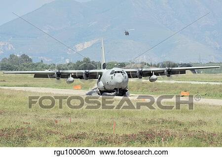 A C-130 Hercules of the Italian Air Force landing on an unpaved landing strip. View Large Photo Image Picture - A C-130 Hercules of the Italian Air Force landing on an unpaved landing strip.. Fotosearch