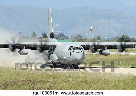 A C-130 Hercules of the Italian Air Force landing on an unpaved landing strip. View Large Photo Image Picture - A C-130 Hercules of the Italian Air Force landing on an unpaved landing strip.. Fotosearch