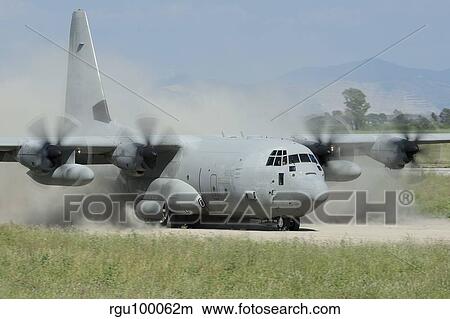Picture - A C-130 Hercules of the Italian Air Force landing on an unpaved landing strip.. Fotosearch