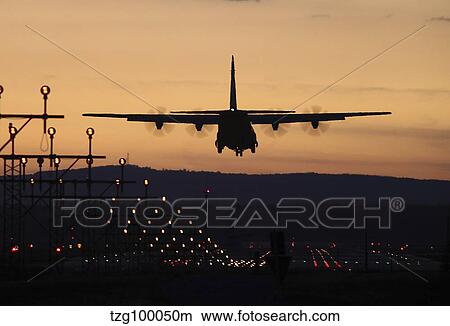 A C-130J Super Hercules landing at Ramstein Air Base, Germany, at dusk. View Large Photo Image Picture - A C-130J Super Hercules landing at Ramstein Air Base, Germany, at dusk.. Fotosearch