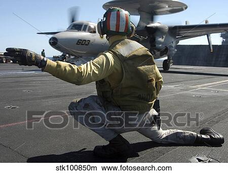 A catapult shooter signals the launch of an E-2C Hawkeye. View Large Photo Image Picture - A catapult shooter signals the launch of an E-2C Hawkeye.. Fotosearch