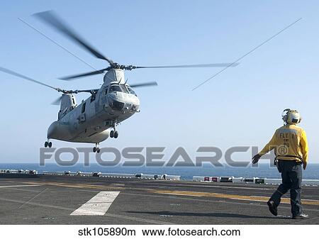A CH-46E Sea Knight helicopter prepares to land on the flight deck of USS Makin Island. View Large Photo Image Picture - A CH-46E Sea Knight helicopter prepares to land on the flight deck of USS Makin Island.. Fotosearch