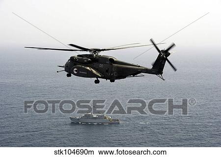 A CH-53 Sea Stallion flies above the mine countermeasures ship USS Ardent. View Large Photo Image Picture - A CH-53 Sea Stallion flies above the mine countermeasures ship USS Ardent.. Fotosearch