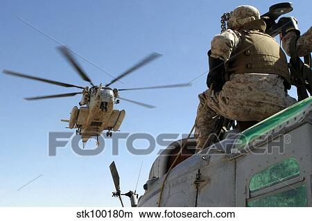 A CH-53 Super Stallion helicopter moves into position to externally lift a UH-1N Huey helicopter. View Large Photo Image Picture - A CH-53 Super Stallion helicopter moves into position to externally lift a UH-1N Huey helicopter.. Fotosearch