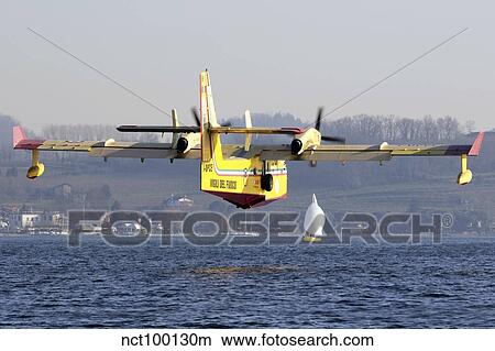 A CL-415 Italian Fire Hunter flying above a lake in Italy. View Large Photo Image Picture - A CL-415 Italian Fire Hunter flying above a lake in Italy.. Fotosearch