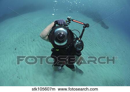 A combat photographer familiarizes himself with an underwater camera. View Large Photo Image Picture - A combat photographer familiarizes himself with an underwater camera.. Fotosearch