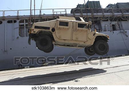 A crane lifts an M998 Humvee on the flight deck of USS Carter Hall. View Large Photo Image Picture - A crane lifts an M998 Humvee on the flight deck of USS Carter Hall.. Fotosearch