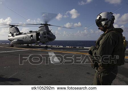 A crew chief watches a CH-46E Sea Knight helicopter aboard USS Makin Island. View Large Photo Image Picture - A crew chief watches a CH-46E Sea Knight helicopter aboard USS Makin Island.. Fotosearch