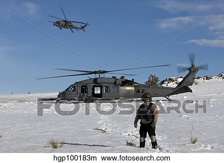 A crewmember of an HH-60G Pave Hawk survey's the landing zone. View Large Photo Image Picture - A crewmember of an HH-60G Pave Hawk survey's the landing zone.. Fotosearch