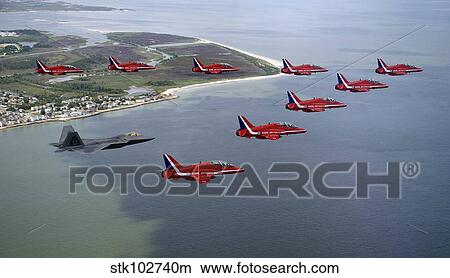 A F-22 Raptor flies in formation with the Royal Air Force Aerobatic Team, The Red Arrows. View Large Photo Image Picture - A F-22 Raptor flies in formation with the Royal Air Force Aerobatic Team, The Red Arrows.. Fotosearch