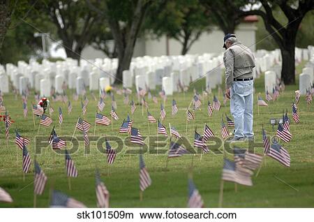 A family member pays his respects at a grave site. View Large Photo Image Picture - A family member pays his respects at a grave site.. Fotosearch