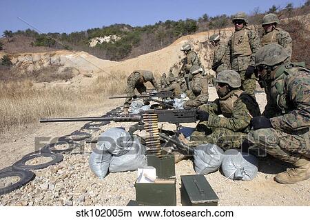 Picture - A field wireman fires an M2. 50 caliber heavy machine gun.. Fotosearch