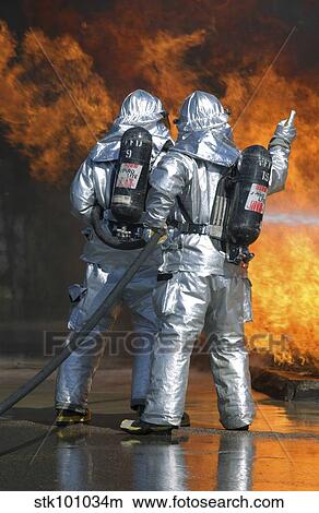A firefighter fights a fire during a readiness training exercise. View Large Photo Image Picture - A firefighter fights a fire during a readiness training exercise.. Fotosearch