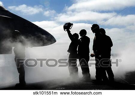 A flight deck crew member shows the pilot of an F/A-18 Hornet the aircraft's weight. View Large Photo Image Picture - A flight deck crew member shows the pilot of an F/A-18 Hornet the aircraft's weight.. Fotosearch