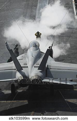 A flight deck director signals an F/A-18F Super Hornet onto catapult one aboard the USS Nimitz. View Large Photo Image Picture - A flight deck director signals an F/A-18F Super Hornet onto catapult one aboard the USS Nimitz.. Fotosearch
