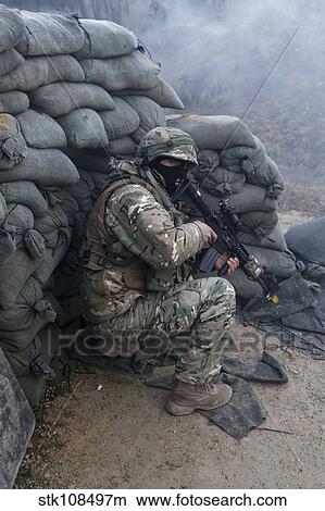 A Georgian soldier takes cover while receiving simulated fire. View Large Photo Image Picture - A Georgian soldier takes cover while receiving simulated fire.. Fotosearch