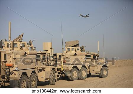 Picture - A German Transall C-160 flies over two EOD Cougar armored vehicles.. Fotosearch