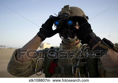 Picture - A Green Beret checks attached night vision device.. Fotosearch
