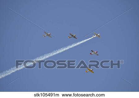 A group of restored vintage warbirds fly in formation. View Large Photo Image Picture - A group of restored vintage warbirds fly in formation.. Fotosearch
