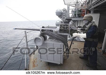 A gunner mans a Mk-38 machine gun aboard USS Kearsarge. View Large Photo Image Picture - A gunner mans a Mk-38 machine gun aboard USS Kearsarge.. Fotosearch