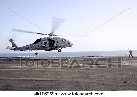 A helicopter landing signalman directs an SH-60F Sea Hawk. View Large Photo Image Picture - A helicopter landing signalman directs an SH-60F Sea Hawk.. Fotosearch