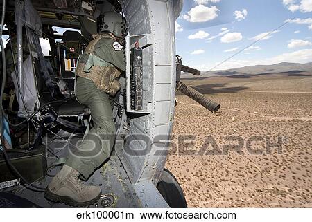 Picture - A HH-60G Pave Hawk gunner fires his GAU-17 machine gun.. Fotosearch