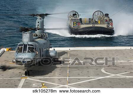 A hovercraft approaches USS New Orleans as a CH-46E Sea Knight sits on the flight deck. View Large Photo Image Picture - A hovercraft approaches USS New Orleans as a CH-46E Sea Knight sits on the flight deck.. Fotosearch