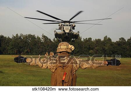 A landing support specialist guides a CH-53E Super Stallion. View Large Photo Image Picture - A landing support specialist guides a CH-53E Super Stallion.. Fotosearch