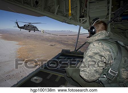 A loadmaster on an HC-130 watches as an HH-60G Pave Hawk refuels. View Large Photo Image Picture - A loadmaster on an HC-130 watches as an HH-60G Pave Hawk refuels.. Fotosearch