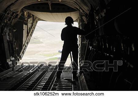 A loadmaster watches supplies airdrop out of the C-27J Spartan. View Large Photo Image Picture - A loadmaster watches supplies airdrop out of the C-27J Spartan.. Fotosearch
