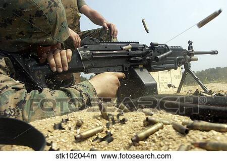 Picture - A Marine engages targets with an M-249 Squad Automatic Weapon.. Fotosearch