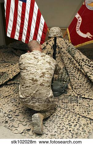 A marine kneels before the rifle, boots and identification tags during a memorial service View Large Photo Image Picture - A marine kneels before the rifle, boots and identification tags during a memorial service. Fotosearch