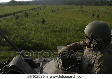 A Marine looks on from the turret of an M1A1 Main Battle Tank. View Large Photo Image Picture - A Marine looks on from the turret of an M1A1 Main Battle Tank.. Fotosearch
