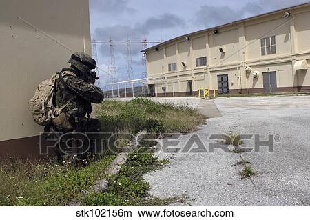 A Marine posts security as a team of Marines prepare to enter an enemy warehouse. View Large Photo Image Picture - A Marine posts security as a team of Marines prepare to enter an enemy warehouse.. Fotosearch