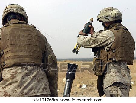 A Marine prepares to drop a high explosive round into a mortar tube. View Large Photo Image Picture - A Marine prepares to drop a high explosive round into a mortar tube.. Fotosearch
