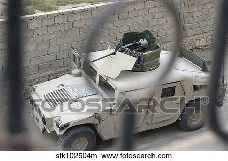 Picture - A Marine provides security with his M2. 50 caliber machine gun atop a humvee.. Fotosearch
