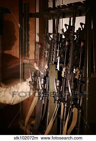 A Marine pulls an M-4 rifle off of the weapons rack. View Large Photo Image Picture - A Marine pulls an M-4 rifle off of the weapons rack.. Fotosearch