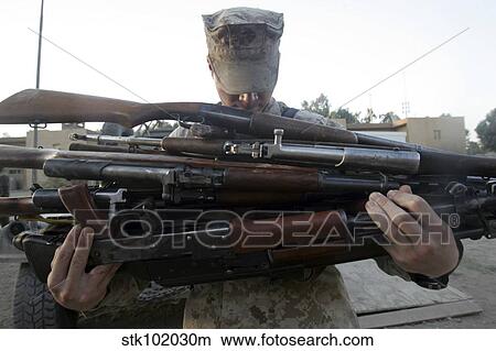 A marine readies 80 pounds of enemy rifles seized. View Large Photo Image Picture - A marine readies 80 pounds of enemy rifles seized.. Fotosearch