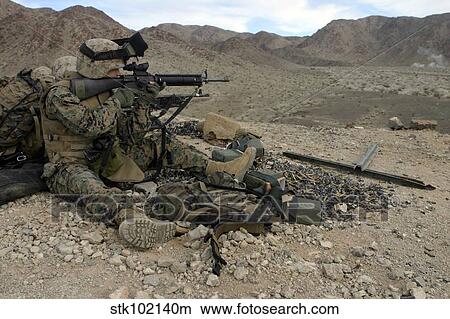 A Marine rifleman provides security for machine gunners atop a hill. View Large Photo Image Picture - A Marine rifleman provides security for machine gunners atop a hill.. Fotosearch