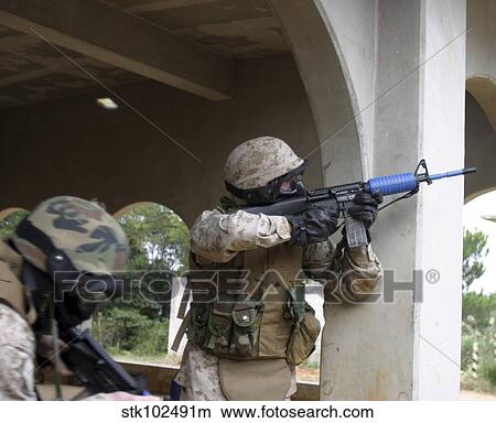 A Marine shoots at an enemy sniper. View Large Photo Image Picture - A Marine shoots at an enemy sniper.. Fotosearch