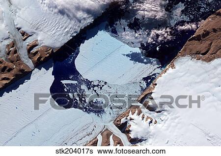 A massive ice island breaks free of the Petermann Glacier in Greenland. View Large Photo Image Stock Photograph - A massive ice island breaks free of the Petermann Glacier in Greenland.. Fotosearch