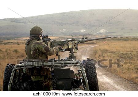 Picture - A member of the Pathfinder Platoon fires a heavy machine gun atop a Land Rover.. Fotosearch