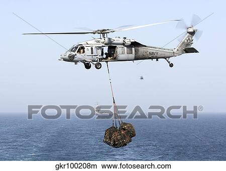 A MH-60 helicopter transfers cargo during a vertical replenishment. View Large Photo Image Picture - A MH-60 helicopter transfers cargo during a vertical replenishment.. Fotosearch