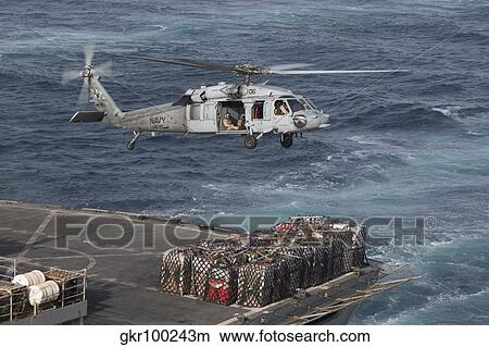 A MH-60S Knighthawk conducts a vertical replenishment at sea. View Large Photo Image Picture - A MH-60S Knighthawk conducts a vertical replenishment at sea.. Fotosearch